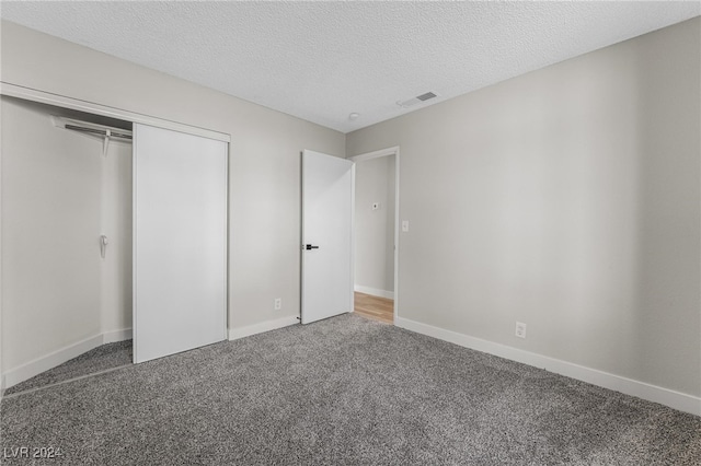 unfurnished bedroom featuring a closet, carpet floors, and a textured ceiling