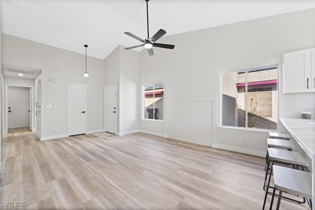 unfurnished living room featuring ceiling fan, high vaulted ceiling, and light hardwood / wood-style flooring