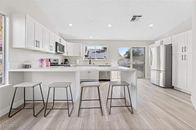 kitchen featuring white cabinetry, a breakfast bar area, and appliances with stainless steel finishes