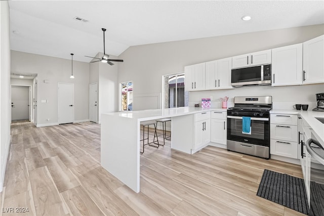 kitchen featuring kitchen peninsula, appliances with stainless steel finishes, ceiling fan, white cabinets, and light hardwood / wood-style floors