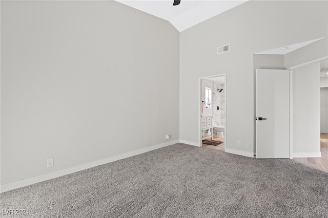 unfurnished bedroom with high vaulted ceiling, ceiling fan, light carpet, and connected bathroom