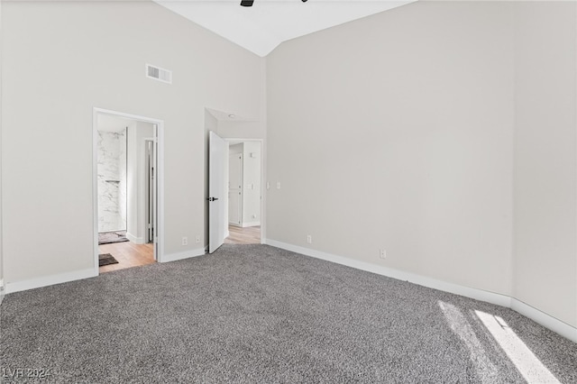 unfurnished bedroom with high vaulted ceiling, ceiling fan, carpet floors, and connected bathroom