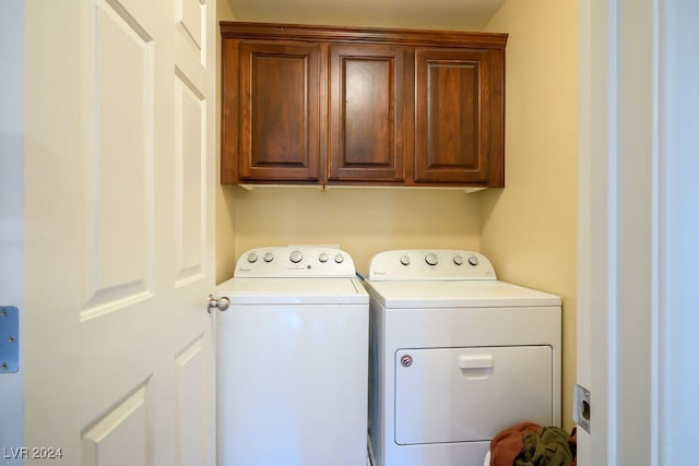 clothes washing area featuring cabinets and independent washer and dryer