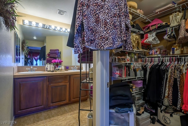 spacious closet featuring light tile patterned floors and sink