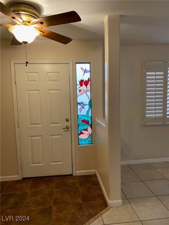 tiled foyer with ceiling fan