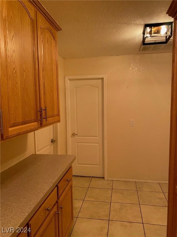 interior space with light tile patterned floors and a textured ceiling