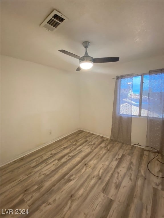 unfurnished room with hardwood / wood-style flooring and ceiling fan