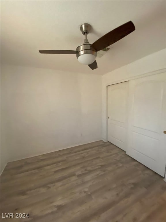 unfurnished bedroom with a closet, dark hardwood / wood-style floors, and ceiling fan