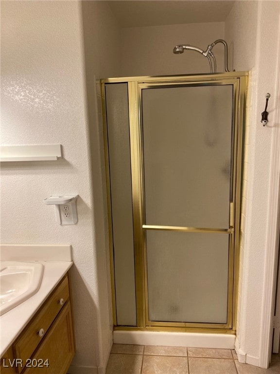 bathroom featuring tile patterned floors, vanity, and a shower with door