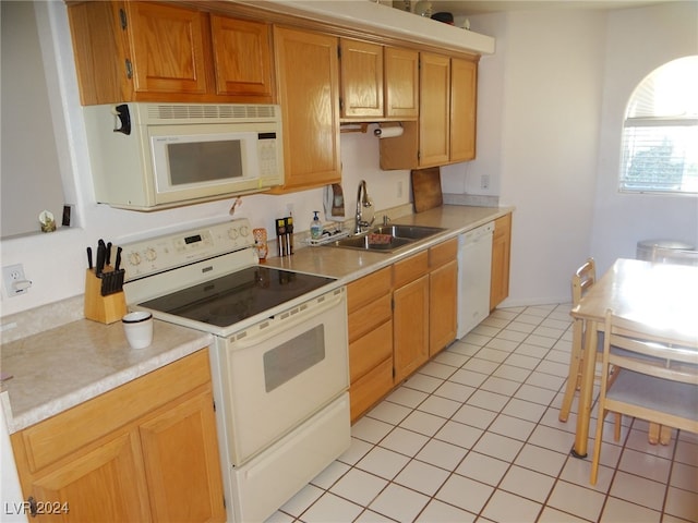 kitchen with light tile patterned floors, white appliances, and sink