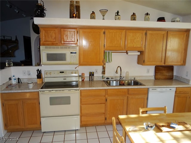 kitchen featuring lofted ceiling, sink, light tile patterned floors, and white appliances