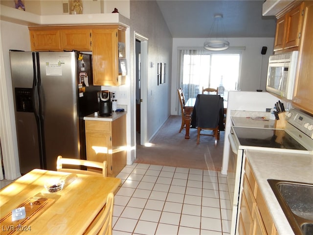 kitchen featuring sink, hanging light fixtures, lofted ceiling, light tile patterned floors, and appliances with stainless steel finishes