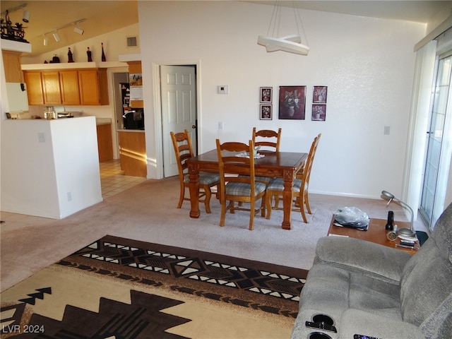 carpeted dining area featuring vaulted ceiling