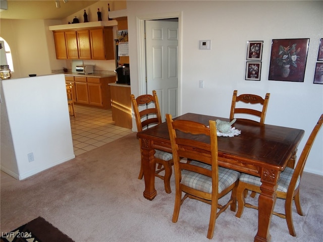 dining room with lofted ceiling and light tile patterned flooring