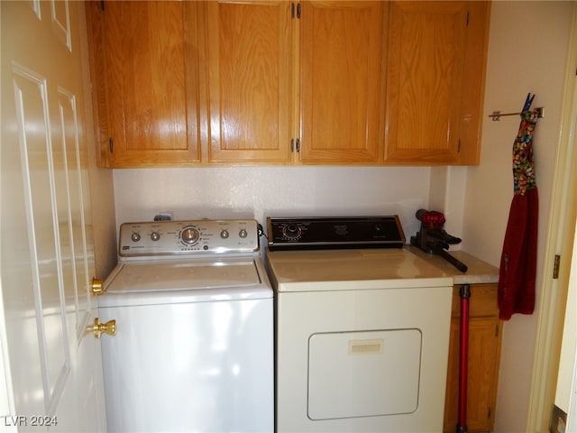 clothes washing area with cabinets and independent washer and dryer