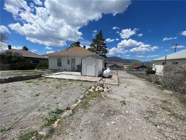 rear view of property featuring a mountain view and a shed