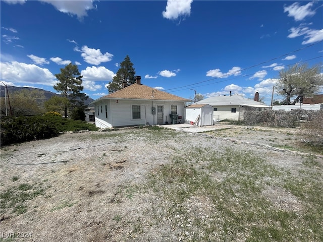 back of property featuring a storage unit