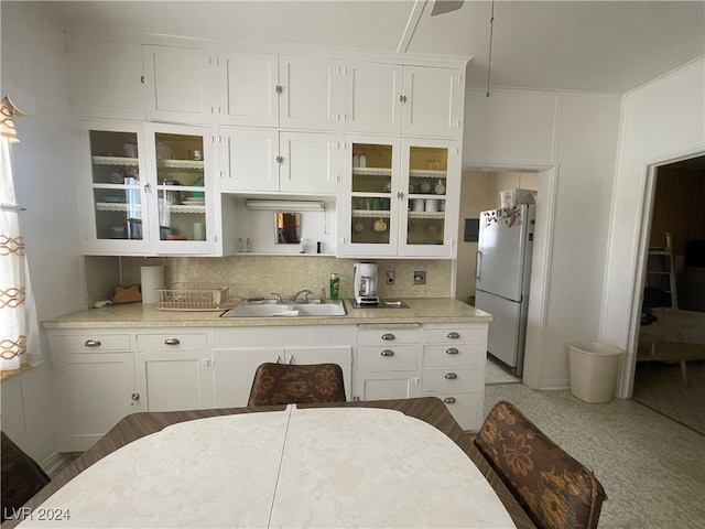 kitchen featuring decorative backsplash, white cabinetry, sink, and white refrigerator