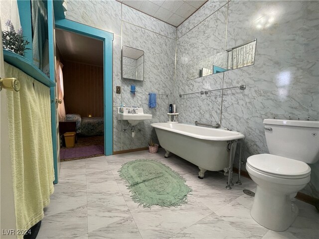 bathroom with a tub to relax in, tile walls, and toilet