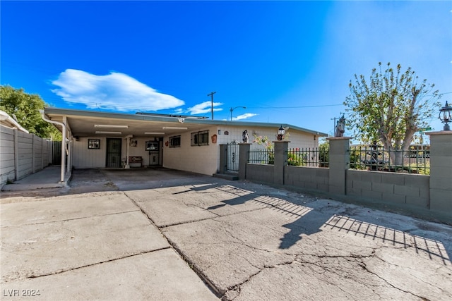 single story home with a fenced front yard, an attached carport, and driveway