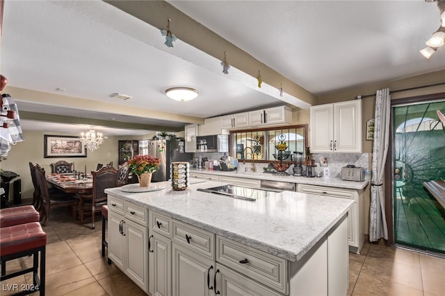 kitchen featuring backsplash, a center island, light tile patterned floors, stainless steel appliances, and white cabinetry