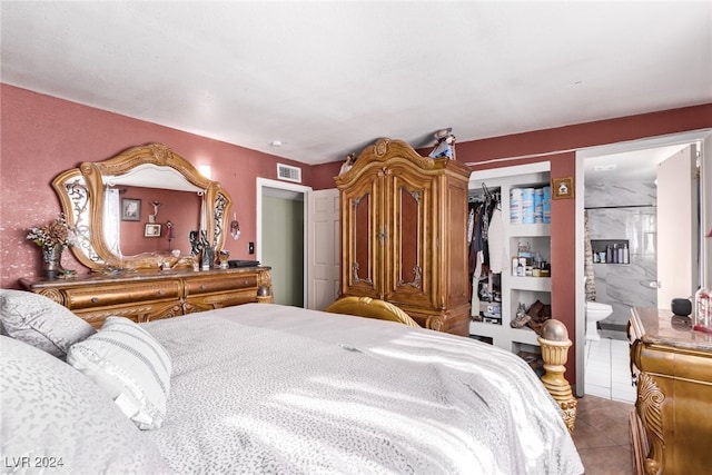 bedroom featuring tile patterned floors, visible vents, a closet, and connected bathroom