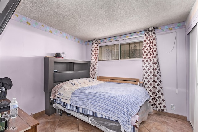 bedroom with tile patterned flooring and a textured ceiling