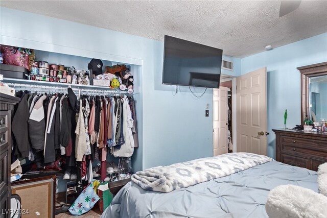 bedroom featuring a closet, visible vents, and a textured ceiling