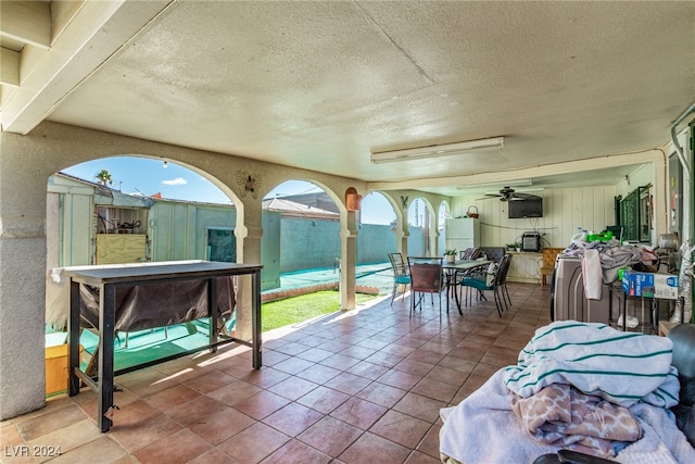 sunroom / solarium featuring washer / dryer and a ceiling fan