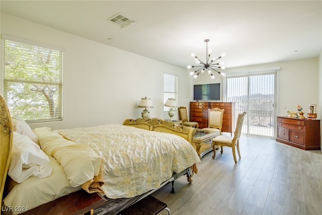 bedroom with access to exterior, a chandelier, multiple windows, and light wood-type flooring