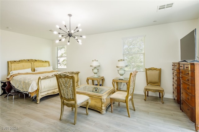 bedroom featuring light hardwood / wood-style flooring and an inviting chandelier