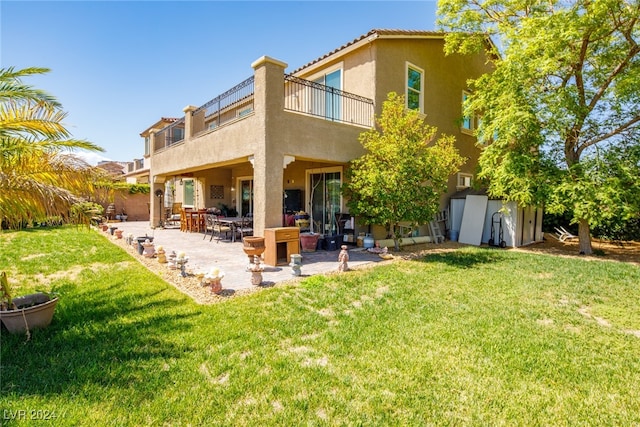 rear view of property with a yard, a patio area, a balcony, and a storage shed