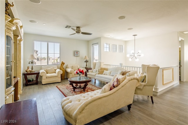 living room featuring light hardwood / wood-style flooring and ceiling fan with notable chandelier