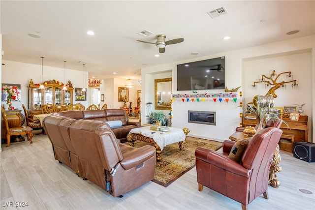 living room with ceiling fan and light wood-type flooring