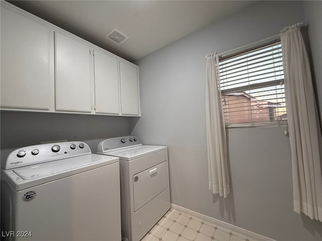 laundry room featuring cabinets and washer and dryer