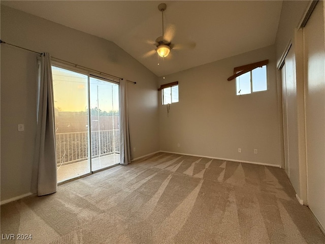 unfurnished room with ceiling fan, light colored carpet, and vaulted ceiling