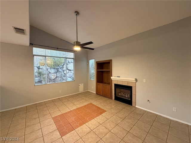 unfurnished living room with a tile fireplace, ceiling fan, light tile patterned flooring, and lofted ceiling