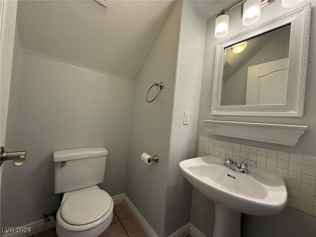 bathroom featuring tasteful backsplash, tile patterned floors, a textured ceiling, sink, and toilet