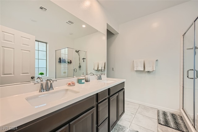 bathroom with tile patterned floors, a shower with door, and vanity