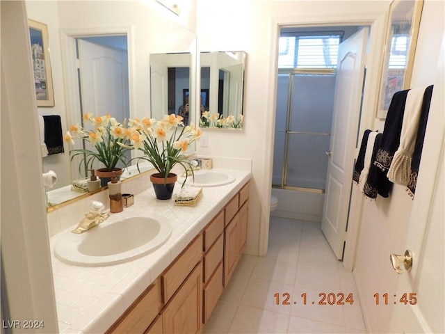 full bathroom featuring shower / bath combination with glass door, vanity, tile patterned flooring, and toilet