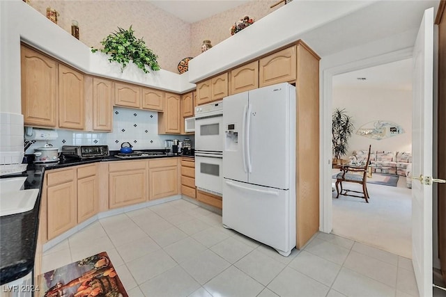 kitchen with light colored carpet, white appliances, light brown cabinetry, and tasteful backsplash