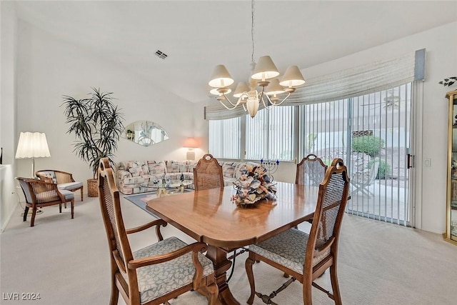 carpeted dining space with vaulted ceiling and a chandelier