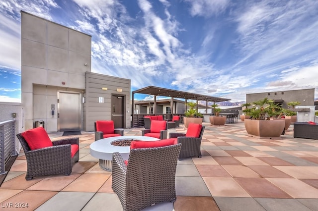 view of patio with elevator and a fire pit