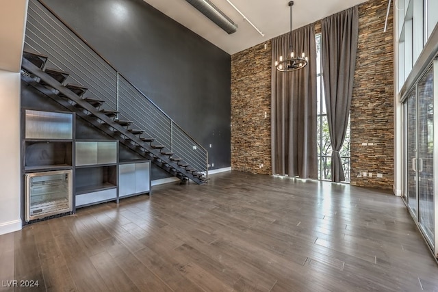 interior space featuring a high ceiling, a notable chandelier, and wood-type flooring