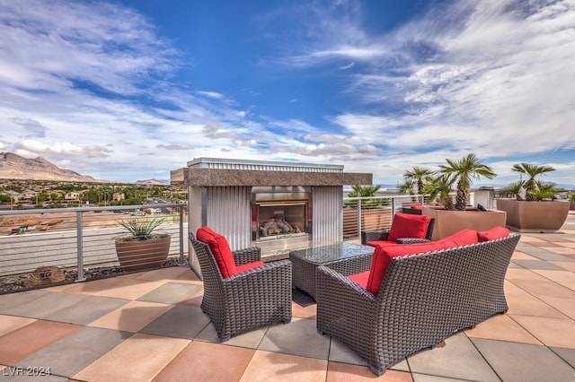 view of patio / terrace featuring a mountain view and exterior fireplace