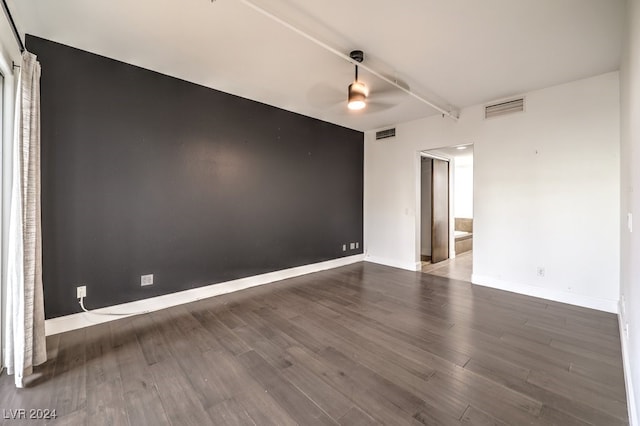 unfurnished room featuring ceiling fan and dark wood-type flooring