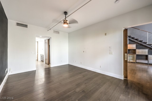 unfurnished room with ceiling fan and dark wood-type flooring