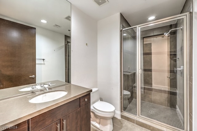 bathroom with tile patterned flooring, vanity, an enclosed shower, and toilet