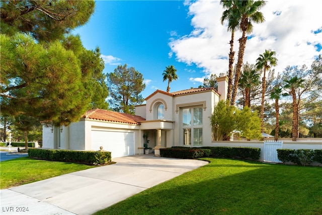 mediterranean / spanish-style home with a garage and a front lawn