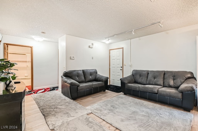 living room with a textured ceiling and hardwood / wood-style flooring